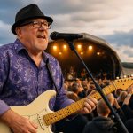 Engaged crowd at a blues concert, hands raised, enjoying live music.